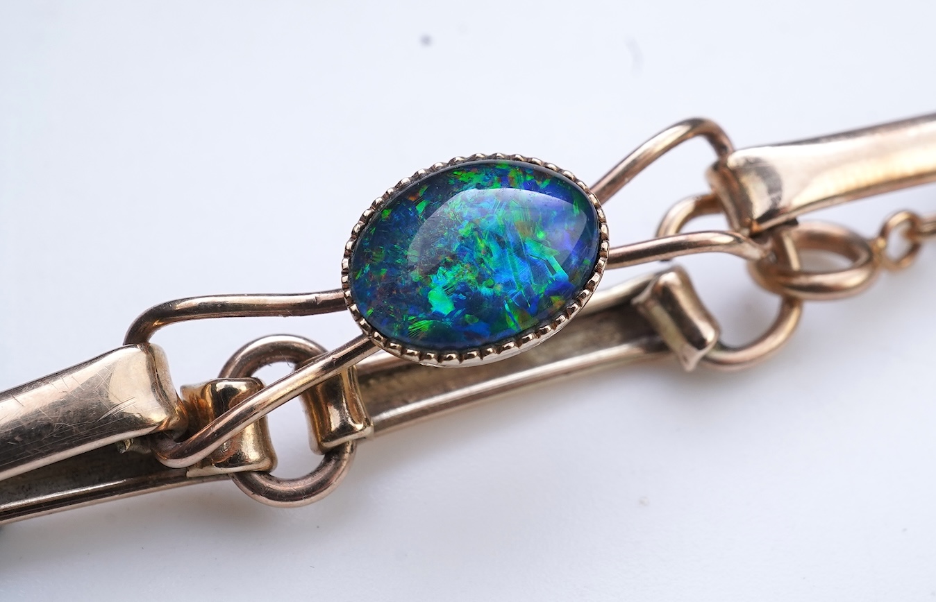 An opal triplet bracelet and pair of earrings, comprising: a gold bracelet set with opal triplets, length 18cm; and a pair of studs set with opal doublets, mounted in gold, length 0.8cm each, post fittings, stamped 585,